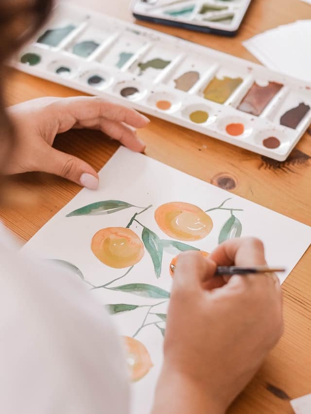 person painting a orange